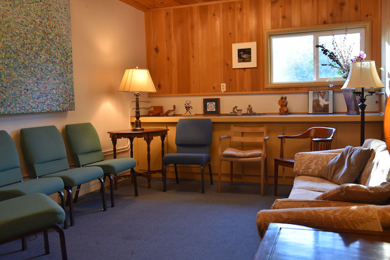 Peace House room rentals include a small room, lined with chairs and a couch.