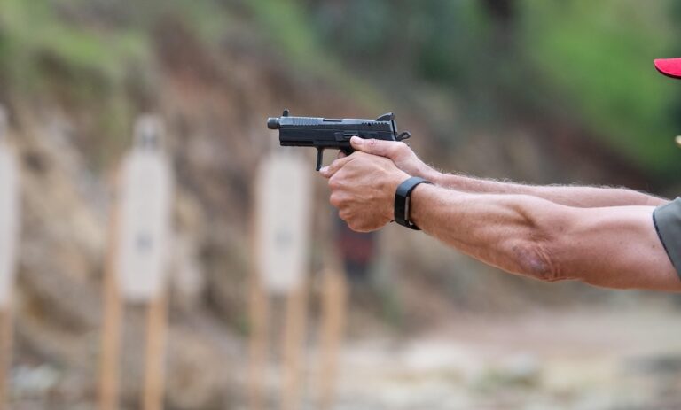 picture of hand holding a gun at a target range